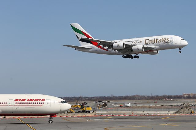 Airbus A380-800 (A6-EDM) - Emirates 201 landing on 22R while the Air India B772 looks on.  6 April 2015