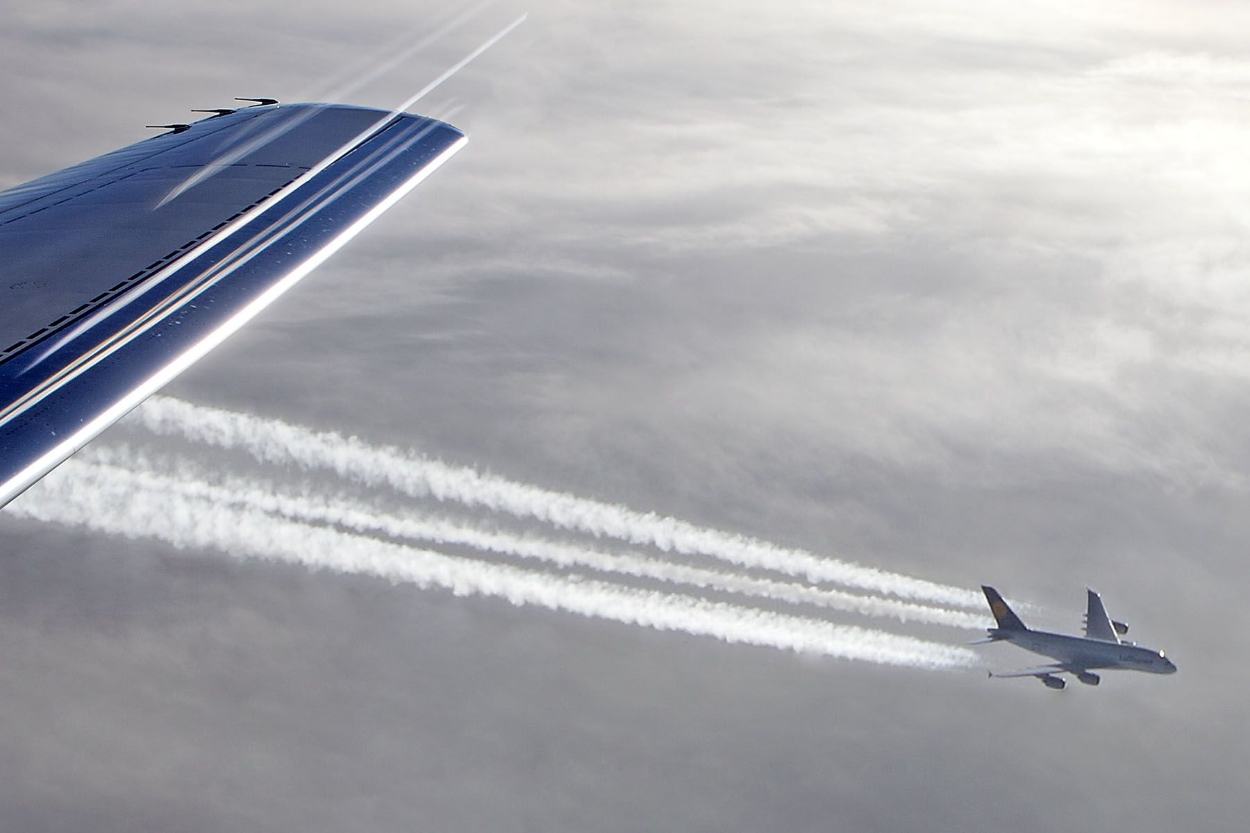 — — - A380 over Atlantic - telephoto lens appears to bring a/c closer - flare/streaks over wing as exposed into light