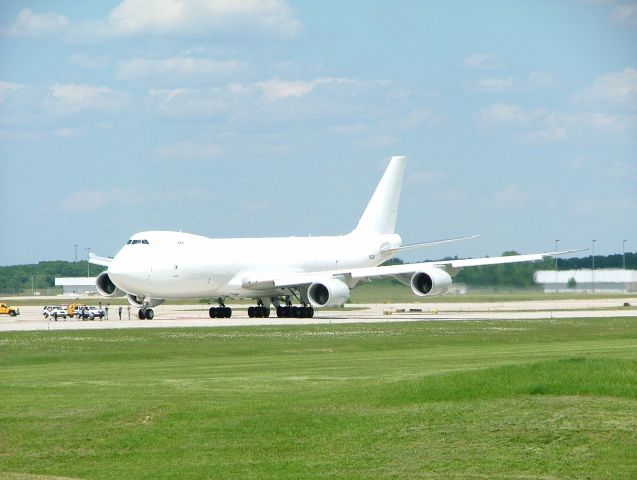 BOEING 747-8 (N6009F) - Rare shot of Boeing 747-8 landing at KGRR. Note airport personnel watching from taxiway.