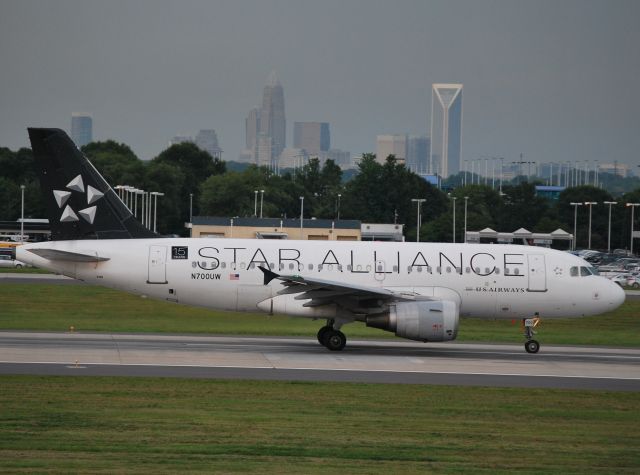 Airbus A319 (N700UW) - Rolling 18C with "The Queen City" in the background - 7/19/12