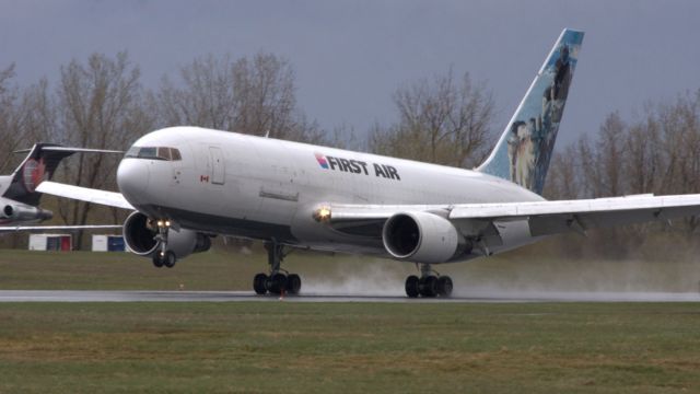 BOEING 767-200 (C-GKLY) - Touching down on a rain soaked Rwy 25 in strong crosswinds.