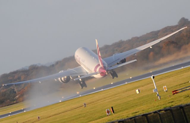 BOEING 777-200LR (A7-BBC) - Qatars new B77.2 gets airborne, streaming condensation over the uper wing surfaces.