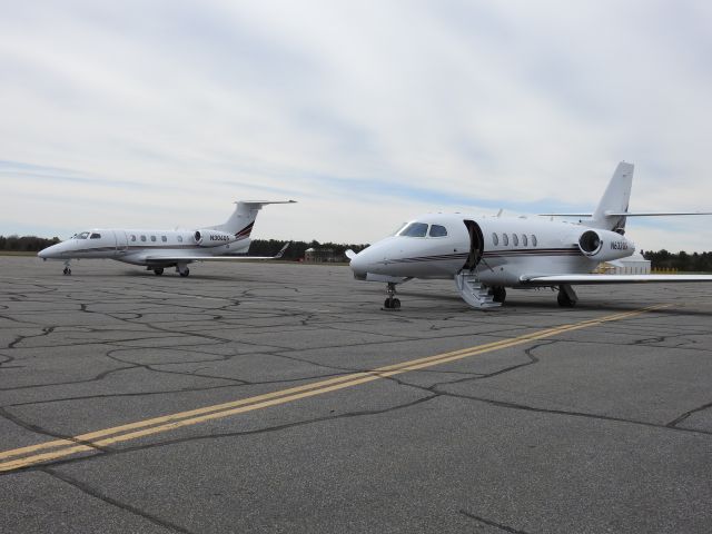 Embraer Phenom 300 (N304QS) - A couple of NetJets await passengers at Muskoka CYQA