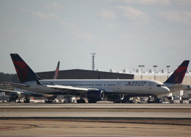 Boeing 757-200 (N662DN) - Passing parked airplane while landing on 27L at ATL on 02/25/2011