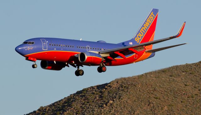 Boeing 737-700 (N793SA) - The setting sun is illuminating the western side of Rattlesnake Mountain and Southwests "Spirit One" (N793SA) as it glides past The Snake while covering the final few thousand feet of its s/final approach to Reno Tahoe Internationals runway 34L.  N793SA bears the name "Spirit One" in recognition of its being the first Southwest fleetbird to wear the "Canyon Blue" clothes way back when it joined the SWA fleet.  This is my first-ever capture of Spirit One, and it came as a tremendous surprise to me; when it first came into view approaching RTIA from the south I made no move to get into position to snap it.  It was only at the last second that I scurried over to shoot it after realizing how well the brilliantly setting sun would light it up.  Didnt even know Id caught "Spirit One" until after it had landed.  