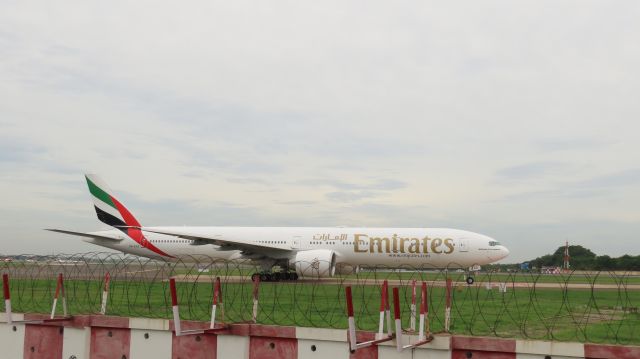 BOEING 777-300ER (A6-EGG) - Holding short of Rwy 25 for arrival