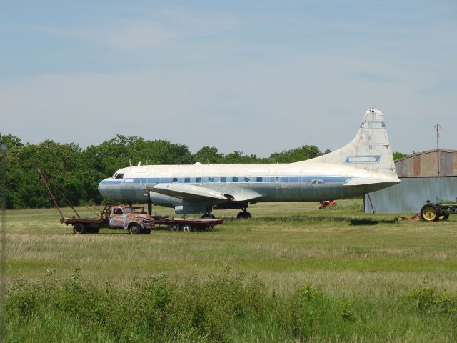 — — - Convair sitting on grass run way.