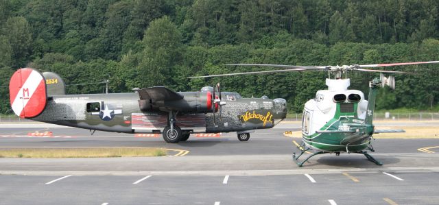 Bell 412 (N420EV) - Collings Foundations B-24J taxiing past Evergreen Aviations N420EV 6-20-09.