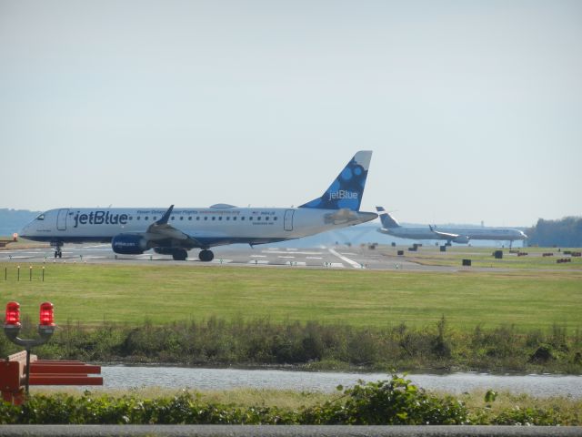 Embraer ERJ-190 (N184JB) - N184JB, A Embraer ERJ-190 Of JetBlue, Lines Up On Runway 1/19, On The Right Side Is N75853, A Boeing 757-200 Of United Airlines, Taxiing To The Gate After Just Landing On The Same Runway