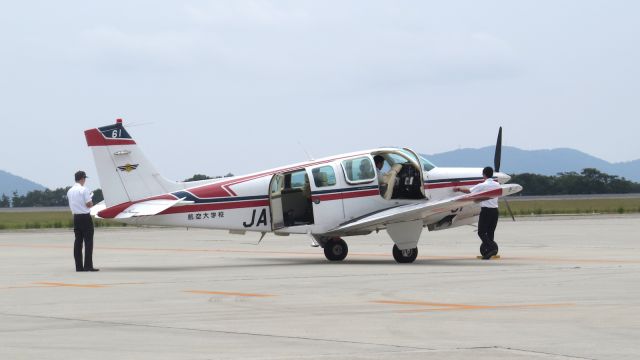 Beechcraft Bonanza (36) (JA4161) - Young student pilots doing their pre-flight check on their Bonanza belonging to the Civil Aviation College flight school. One day they will become the next generation airline pilots.