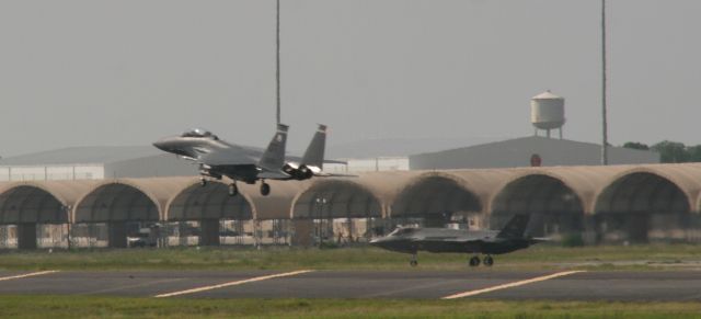 McDonnell Douglas F-15 Eagle — - F-15 Eagle passing over a patiently waiting F-35 JSF. I was driving north out of Destin passing Eglin AFB where they had numerous jets performing touch & gos. I pulled over and took photos of this impromptu airshow.