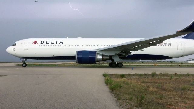 BOEING 767-300 (N174DZ) - Delta B767 taxiing for take off during thunderstorm. Unfortunately I took this photo with a smartphone thus the poor quality.