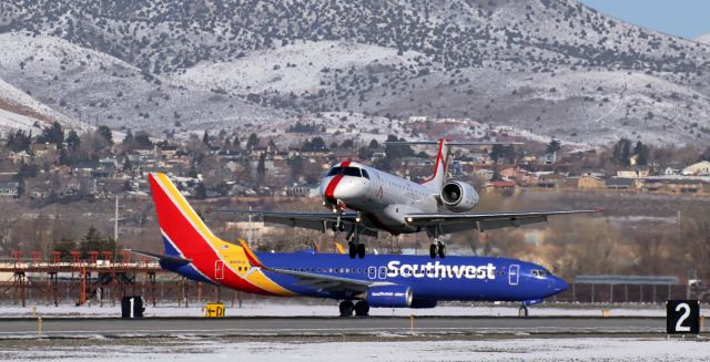 Embraer ERJ-135 (N256JX) - JSX's N256JX, arriving from Bob Hope (Burbank, CA; KBUR), has passed over the keys and is beginning to flare to land on 17L while Southwest's N8691A, a B738, waits at the 17L HOLD line for tower permission to line up and depart for a trip downstate to KLAS.