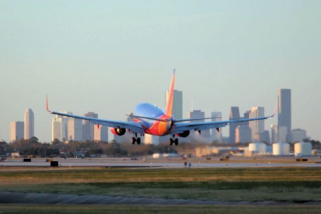 — — - Southwest Airlines landing with the Houston skyline in the background. (12-12-2010)