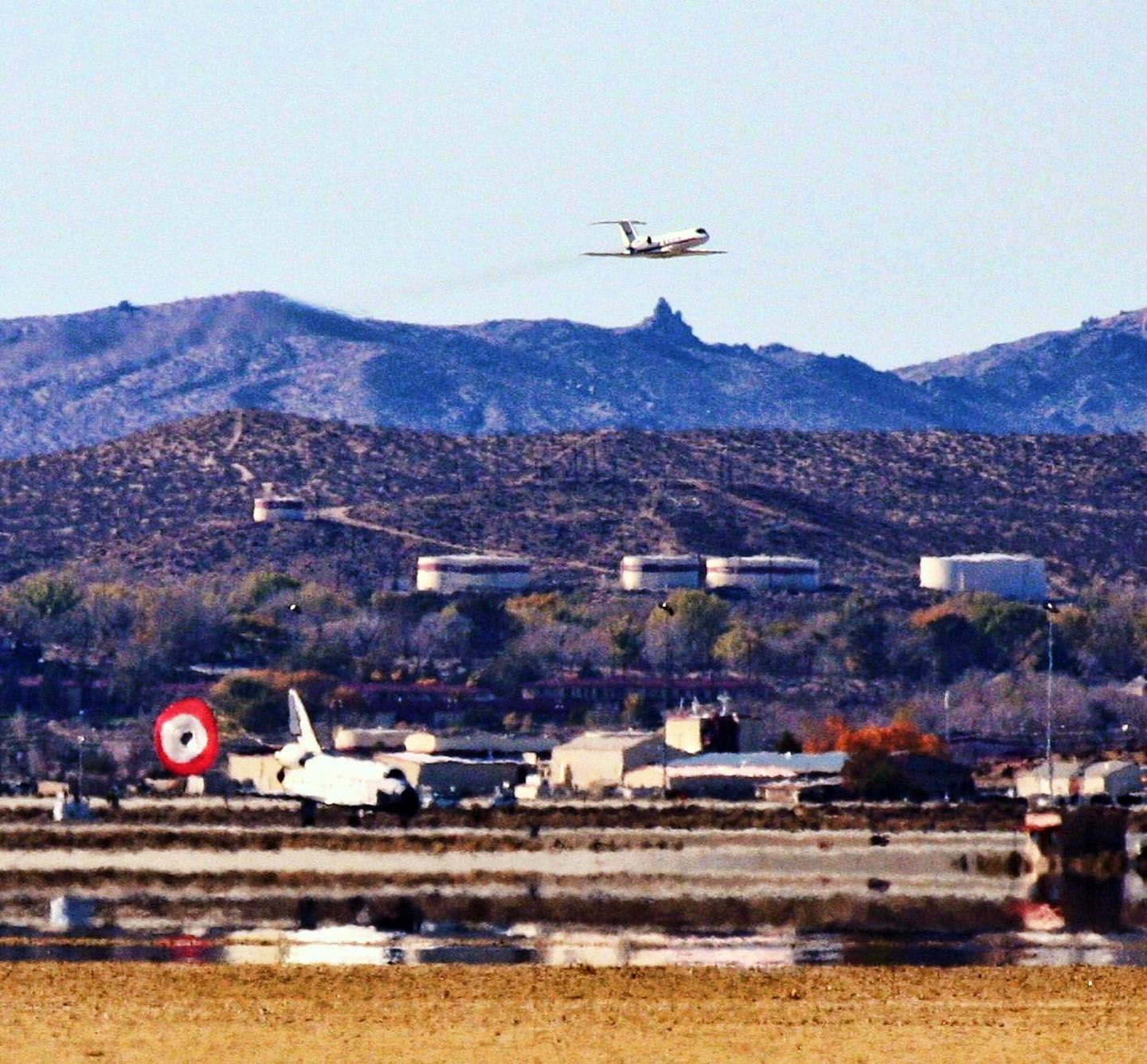 ELL105 — - This is the shuttle Endeavour landing at Edwards AFB. I was very far away when this photo was taken with my 100-400 mm lens. At least I captured the shoot coming out and the spotter plane.