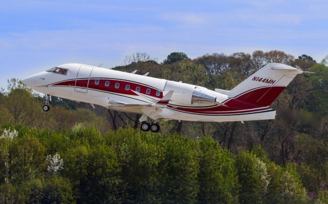 Canadair Challenger (N144MH) - N144MH is a 1993 Bombardier Challenger 600 seen here departing Atlanta's PDK executive airport. I shot this on a beautiful Spring day with the flowering trees in bloom. I thought the sharpness of this photo was fantastic. This photo was shot with a Canon 200-400mm F4 lens at the focal length of 243mm. Camera settings were 1/2000 shutter, F5.6, ISO 200. Please check out my other aviation photography. Votes and positive comments are greatly appreciated. Inquiries about prints or licensing of this photo can be sent to Info@Flews.com