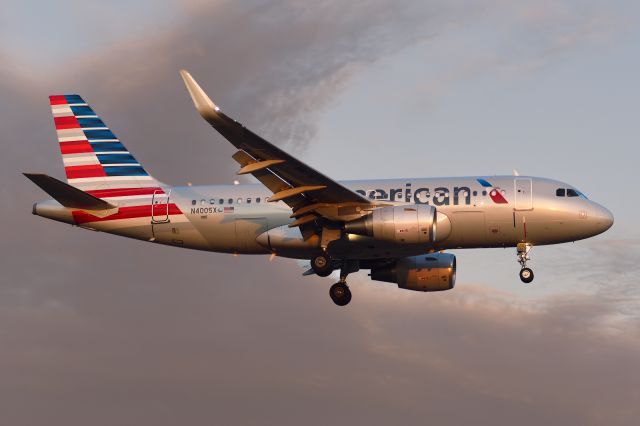 Airbus A319 (N4005X) - Captured on short final to 19R precisely at sunset. The sunset can be seen reflecting on the nose of the aircraft. Nikon D750, Sigma 70-200 F2.8. 