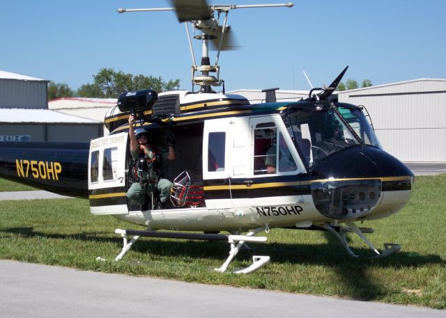 N750HP — - Photo depicts the Tennessee Highway Patrols UH-1V Iroquois (aka the Huey of Vietnam fame) preparing to depart the Tullahoma Regional Airport (KTHA) enroute to a rescue scene near Monteagle TN.  Note the crew member preparing to attach the winch to the Stokes litter basket in the aircraft cabin; on this particular flight, the helicopter (reportedly) had to winch accident survivors off the mountains near Monteagle TN.  I shot the photo with my Kodak V1233 Zoom Digital Camera at 3:50:06 PM CST on 15 June 2008 using 1/400 sec exposure time, and the photo is cropped to an (approximate) 3898 x 2784 pixel value.