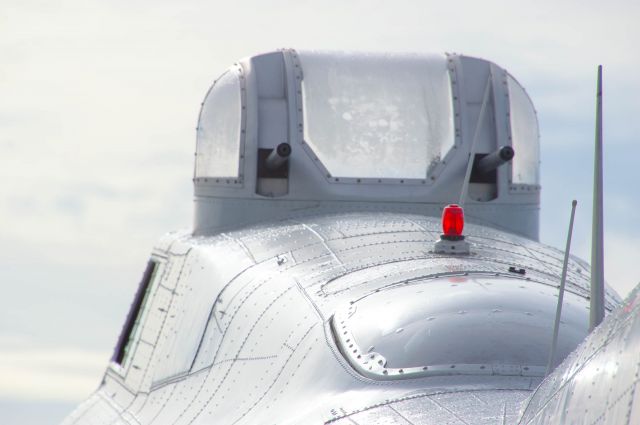 Boeing B-17 Flying Fortress (N5017N) - "Aluminum Overcast" gleams in the early morning slightly overcast sunrise while the crew prefer her for her flights. Here you can see a closeup view from the aft section of the aircraft looking forward with the navigator's seat and beacon light to the upper ball turret. Photo taken Sunday, June 23, 2019 with Nikon D3200 at 350mm.