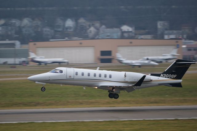 Learjet 40 (N300GF) - With Cincinnati's Linwood neighborhood overlooking, Lear 40 N300GF sets it down on 21L at a busy KLUK.