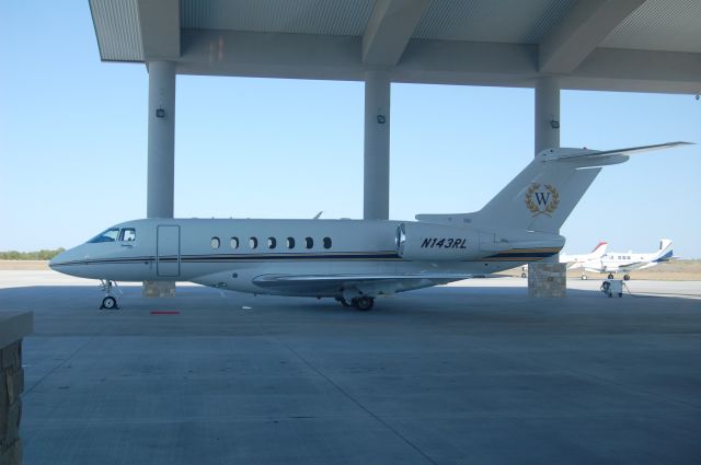 Hawker 800 (N143RL) - Parked under the huge canopy at KEDC