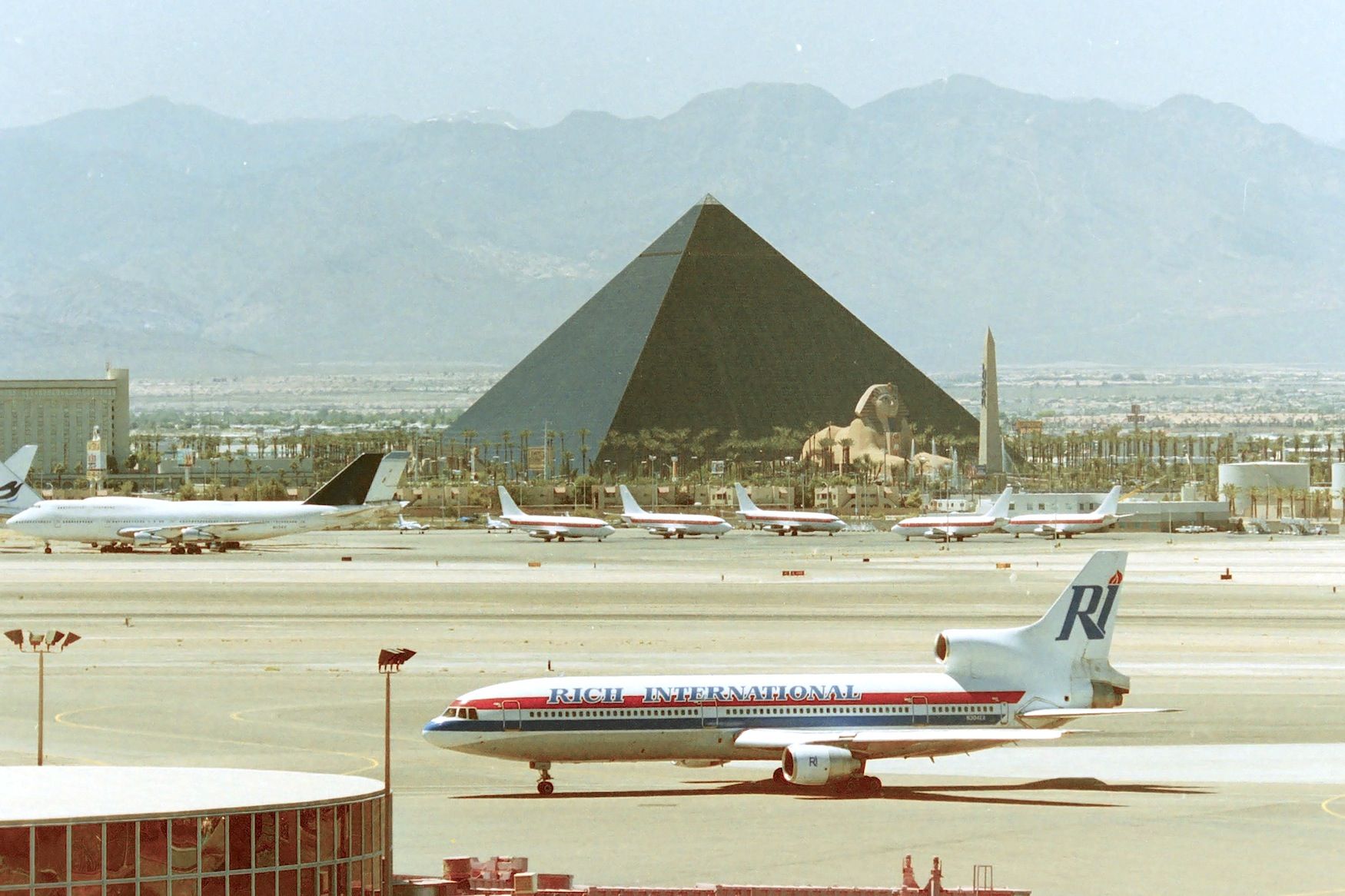 Lockheed L-1011 TriStar (N304EA) - KLAS - July 25, 1995 - 115 degrees and loads of fun. Rich Intl L-1011 on taxi heading for cooler temperatures - view from the top floor of the parking garage - nice that LAS officials have a nice cover for shade up there. delv new to Eastern Airlines 7/11/1972 and flew several different operators, picked up by Rich Intl Oct 1993. CN: 1005. My Fav UFO fleet over at EG&H in front of the Luxor.