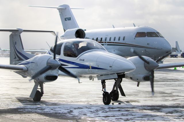 Diamond Twin Star (N327TS) - Oncore aviation da-42 parked in front of a bombardier business jet. Taken Tac Air 