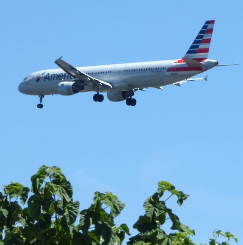 Airbus A321 (N192UW) - Over the trees seconds before landing, summer 2018.