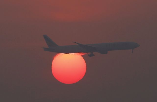 — — - A plane flies over the setting sun in the sky at Beijing International Airport, China, March 2, 2016. (Photo by Kim Kyung-Hoon/Reuters)