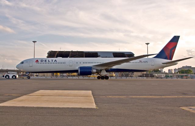 BOEING 767-400 (N825MH) - Original AA hangar demo @ KBOS Logan has started as Delta Airlines B767-400 passes by from their hangar up to the gate to depart to AMS.