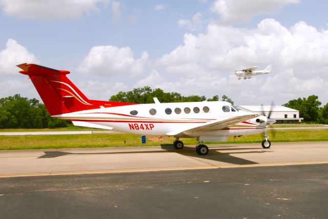 Beechcraft Super King Air 200 (N84XP) - King Air xray papa taxis to 17 while N2141Y, a flight school Cessna 172 lands behind it.