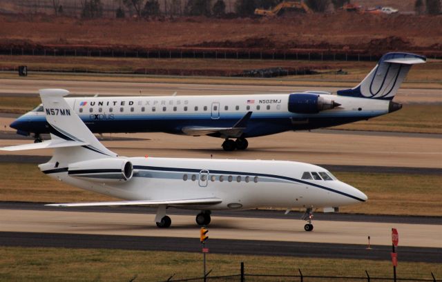 Dassault Falcon 2000 (N57MN) - Taxiing at Washington-Dulles with a UAX CRJ heading to the terminal