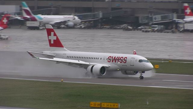 Bombardier CS100 (HB-JCA) - Arriving in the wet!!! Check out the thrust reversers!!