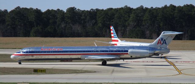 McDonnell Douglas MD-83 (N9681B) - An older Mad Dog shining in the crisp noon day light.  A chivalrous American E190 lets her go past.