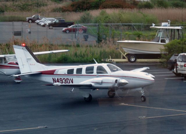 Beechcraft Baron (58) (N493DV) - On the RELIANT AIR ramp. RELIANT AIR has the lowest fuel price on the Danbury (KDXR) airport.