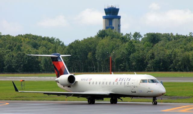 Canadair Regional Jet CRJ-200 (N8964E) - "Flagship" taxiing towards runway 24 with Bradley Tower posing in the background.