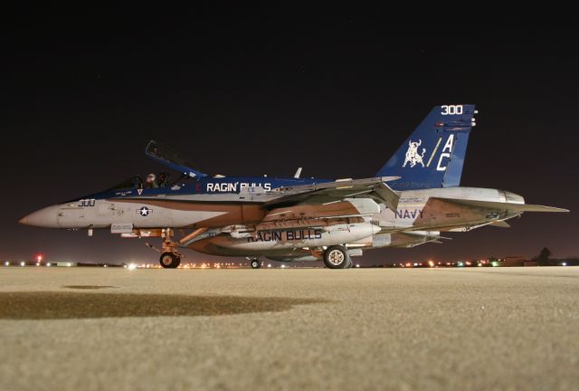 — — - AThe Ragin Bulls F-18C Hornet CAG getting started up for a night launch