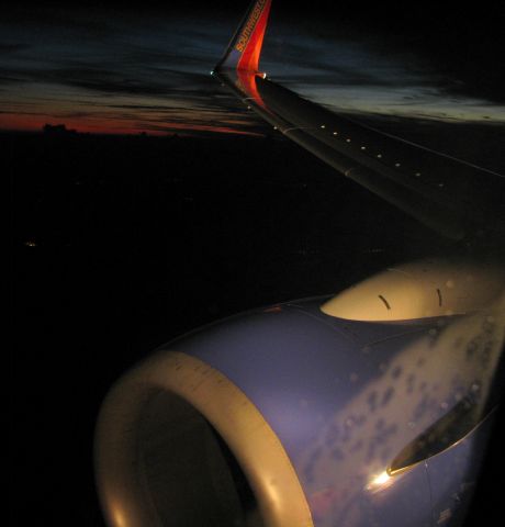 Boeing 737-700 — - Descending into the base leg for approach to Jacksonville. A rather difficult shot considering the slower shutter speed and higher ISO setting needed to take the night shot while bouncing thru mild chop during the descent, but the landing lights helped illuminate the scene and the Canon S5IS point-and-shoot did the rest.