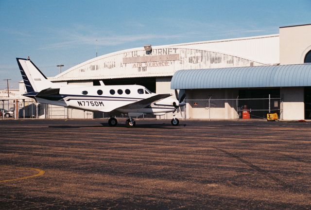 Beechcraft King Air 90 (N775DM) - Beechcraft King Air C90, msn LJ-764, manufactured in 1978 and photographed at KLFT, Lafayette Regional Airport. Parked at Paul Fournet Air Service FBO hangar. Photo taken circa year 2000 with a Canon 35mm camera.