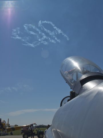 Lockheed T-33 Shooting Star — - Skywriters trace the initials EAA in the sky above Airventure 2011 - with the canopy of a Shooting Star bearing Canadian Air Force markings in the foreground