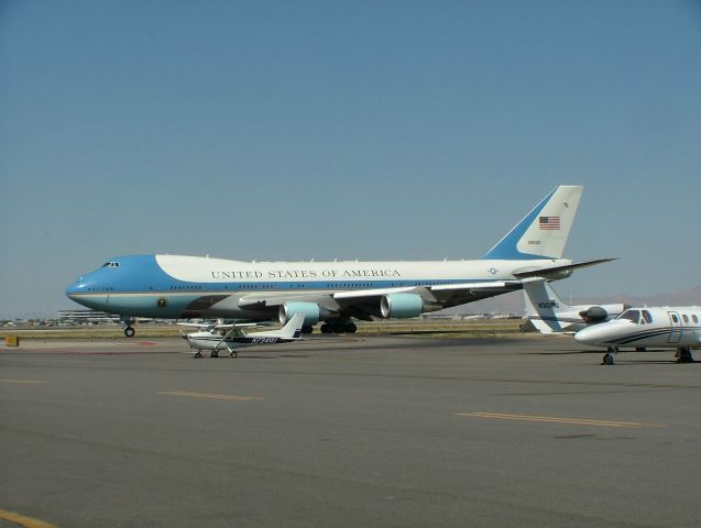 Boeing 747-200 — - Air Force One,  President G.W.Bush visit to Salt Lake City, 2006  I love how the cessna in the foreground is dwarfed by the size of AF-1 even considering it is probably 200 feet closer to the camera.