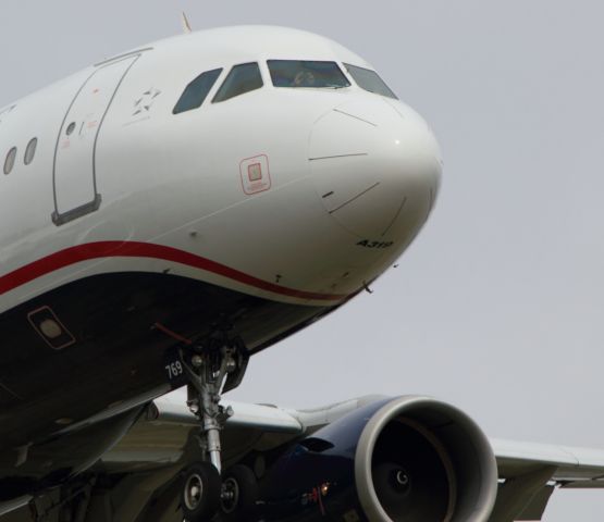 Airbus A319 (N769US) - Who's taking a picture of who? Check out the first officer. Short final runway 19