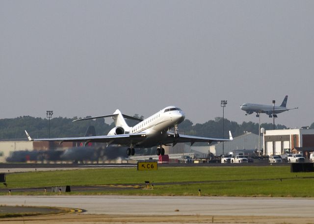 N15PX — - This Bombardier is taking off from runway 18L, Charlotte, North Carolina USA just ahead of a US Airways 320, which is landing on runway 5, an intersecting runway of runway 18L.