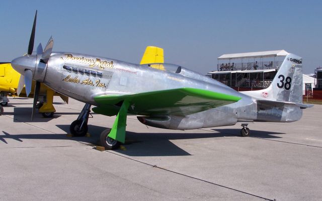 North American P-51 Mustang (N6WJ) - Precious Metal racer at Lakeland, Florida 2006. Engine drives two counter rotating propellers. Notice the Fosters beer cans used to cover the exhaust outlets.