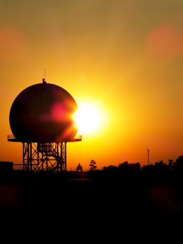 — — - Sunset catch in LHBP, with a golf ball shaped radar and the control tower behind.