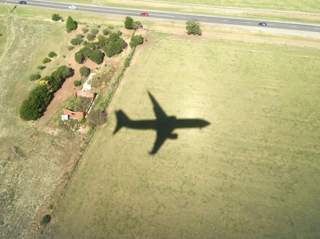 Boeing 737-800 (VH-VZB) - Landing into YMML on Runway 16 from YPAD. Took this photo almost by accident as noticed that the sun was right behind the aircraft which showed a perfect shadow on to the ground.