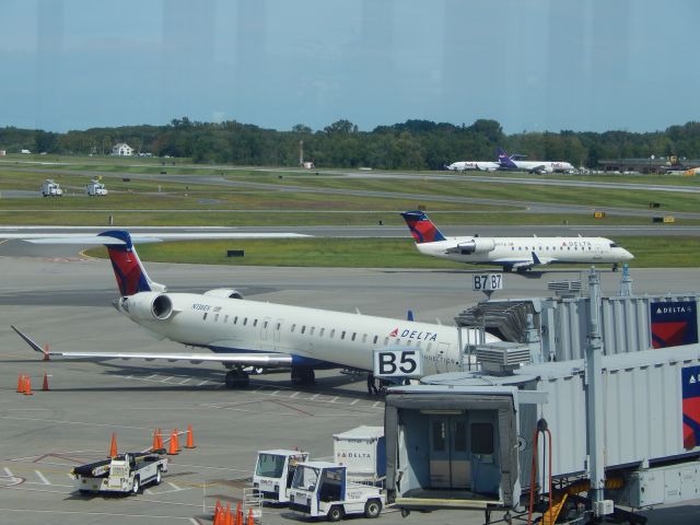 Canadair Regional Jet CRJ-900 (N136EV) - A Delta CRJ900 at ALbany while a CRJ taxis behind it