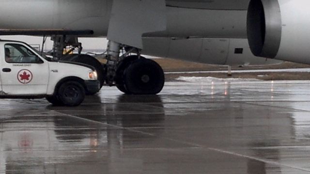 Airbus A330-300 (C-GHLM) - Being towed to the hanger after popping a tire on landing. Look at how flat the wheel is. It is not turing during the tow.2of3