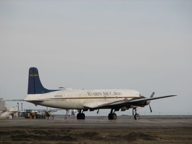 Douglas DC-6 (N6586C) - Waiting for start up in Barrow, Alaska.  Notice the Hageland Caravan in the background.