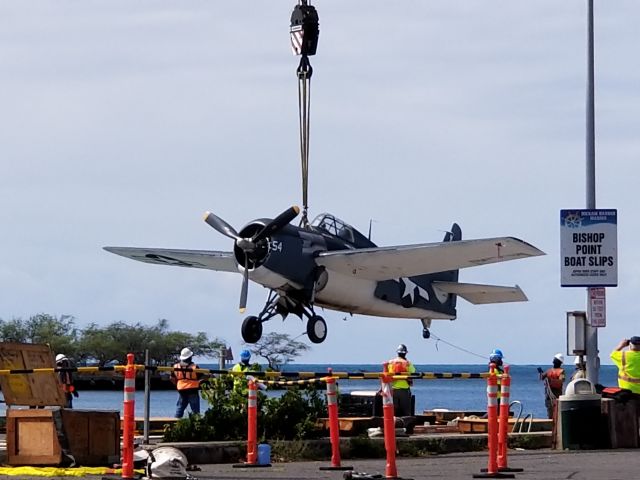 N5833 — - A F4F (FM-2 Wildcat) gets a free flight onto a barge before being loaded onto the USS Essex for a ride from O'ahu to the Mainland.